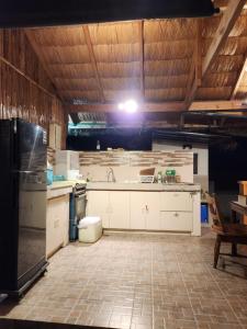 a large kitchen with white cabinets and a tile floor at Guarin House in Sipating