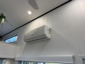 a white kitchen with a stove on the wall at Big Tiny Medlow in Medlow Bath