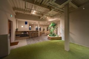 a large room with a plant in the middle of it at 水の郷リトリート 再 in Katori