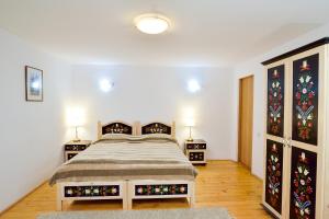 a bedroom with a bed and two night stands at Pension Bassen in Bazna +133 photos