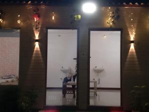 a room with three doors with a person sitting in a chair at Holiday Homestay Beach Rooms Deep Diving & Light House & Watersports Tarkarli in Bhogwe +39 photos