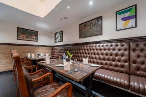 a restaurant with two tables and a leather couch at Treebo Premium Silva Lux in Wayanad