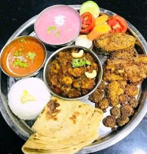 a plate of food with different foods and dips at Holiday Homestay Beach Rooms Deep Diving & Light House & Watersports Tarkarli in Bhogwe