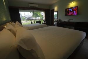 a bedroom with a large white bed and a window at Love Couple in Dhaka