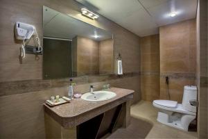 a bathroom with a sink and a toilet and a mirror at Love Couple in Dhaka
