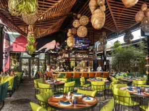 a restaurant with tables and chairs and a bar at Voy House Wynwood with Rooftop Pool in Miami