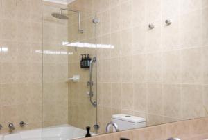 a bathroom with a shower with a tub and a toilet at Harbour View Motel in Robe +85 photos