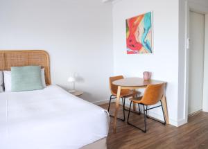 a bedroom with a bed and a table and chairs at Harbour View Motel in Robe