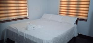 ein Bett mit weißen Laken und Kissen in einem Schlafzimmer in der Unterkunft Tharavad Homestay Athirappilly in Athirappilly