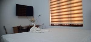 ein weißes Bett mit einer Vogelskulptur darauf in der Unterkunft Tharavad Homestay Athirappilly in Athirappilly