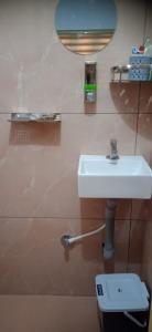 ein Badezimmer mit einem weißen Waschbecken und einer Toilette in der Unterkunft Tharavad Homestay Athirappilly in Athirappilly