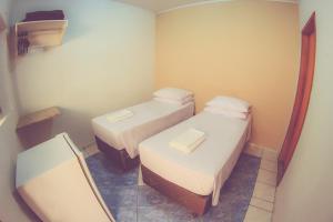 ein kleines Zimmer mit 2 Betten und einem Spiegel in der Unterkunft Vitória Hotel in Monte Alto