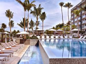 a pool at the resort with lounge chairs and palm trees at Andaz Maui at Wailea Resort - A Concept by Hyatt in Wailea