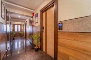 a hallway with a door and plants in a building at Treebo Viswa Vikas Residency in Coimbatore