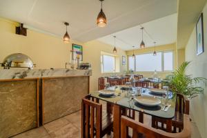 a dining room with a table and a kitchen at Treebo Viswa Vikas Residency in Coimbatore