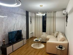 a living room with a couch and a flat screen tv at Aspen Pirin View in Razlog