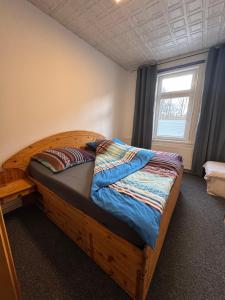 a wooden bed in a room with a window at Steigerstube in Clausthal-Zellerfeld