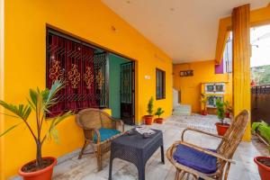 a room with a table and chairs and a yellow wall at Karthees Homestay in Rāmeswaram