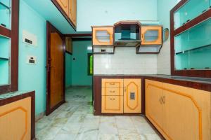 an empty kitchen with orange cabinets and green walls at Karthees Homestay in Rāmeswaram