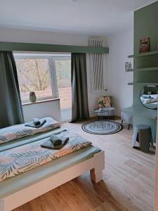 a bedroom with two beds and a large window at Zeitinsel Doos in Waischenfeld