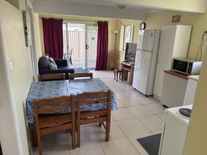a kitchen with a table and chairs and a kitchen with a refrigerator at Toukley Lakeside Apartment in Toukley