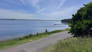 a road next to a large body of water at Toukley Lakeside Apartment in Toukley