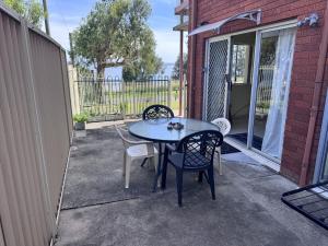 a patio with a table and chairs on a porch at Toukley Lakeside Apartment in Toukley +2 photos