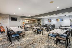 a dining room with tables and chairs and a kitchen at Quality Inn Branson On the Strip in Branson