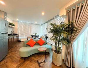 a living room with a couch and a potted plant at Dinh Ami Hanoi Hotel in Hanoi