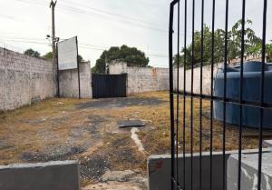 an open gate in a compound with a fence at Maia Hostel in Várzea Grande