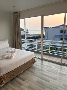 a bedroom with a bed and a large window at Nantra Hua Hin in Hua Hin