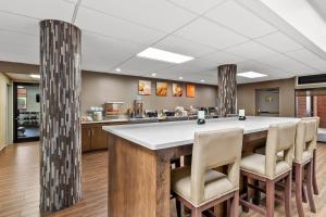 a large kitchen with a large island with chairs around it at Comfort Suites Near Potomac Mills in Woodbridge