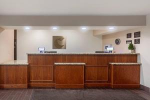 a lobby with a large wooden bar with stools at Comfort Inn & Suites Temple - Medical Center in Temple