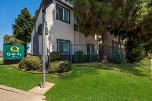 a building with a sign in front of a yard at Quality Inn Yuba City-Marysville in Yuba City