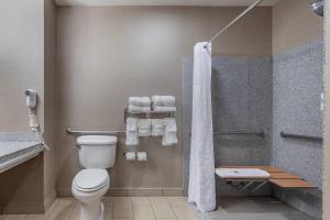 a bathroom with a toilet and a shower with towels at Comfort Suites Boise West Meridian in Meridian +76 photos