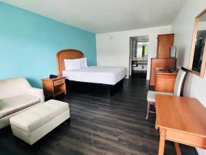 a hotel room with a bed and a couch at Rodeway Inn Clearwater - Central in Clearwater