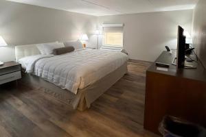 a bedroom with a bed and a desk and a television at Clarion Pointe South Portland in South Portland
