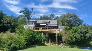 a house with a wrap around porch with trees at Riverfront Guesthouse ,Watermeadows farm in Sedgefield