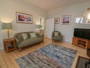 a living room with a couch and a flat screen tv at South Segganwell - Culzean Castle in Maybole