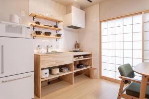 a kitchen with a counter and a table and a refrigerator at フォレステージ嵐山 in Kyoto
