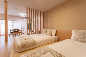 a bedroom with two beds and a dining room at フォレステージ嵐山 in Kyoto
