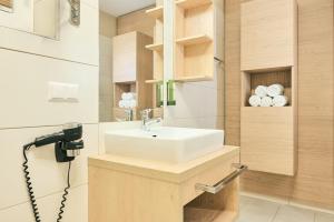 a bathroom with a sink and a mirror at Almresort Gartnerkofel Nassfeld in Sonnenalpe Nassfeld
