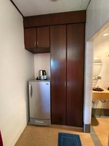 a kitchen with a stainless steel refrigerator and wooden cabinets at Nazri's Place 2 in Tioman Island +39 photos