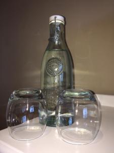 two empty glasses sitting next to a glass bottle at Mooredge - Room only in Whitby