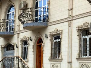 a building with two balconies and a wooden door at Giza Grand Hotel in Tashkent