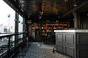 a restaurant with a bar with tables and chairs at Kvosin Downtown Hotel in Reykjavík