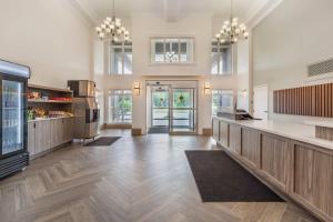 a large room with a kitchen with wooden floors at Velora Hinton, an Ascend Collection Hotel in Hinton