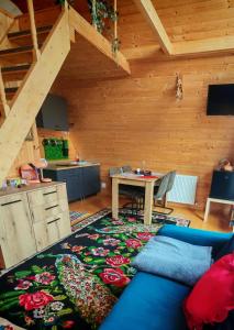 a living room with a blue couch and a table at Carpatina A-Frame Retreat - Rustic Cabins for Couples in Runcu