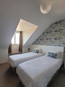 two beds in a room with a attic at Hôtel Port Haliguen in Quiberon
