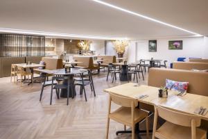 a restaurant with tables and chairs in a room at DoubleTree by Hilton Queenstown in Queenstown